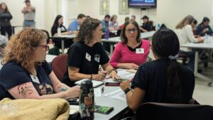 Four women sitting around a table discussing how to proceed with emergency response assignments
